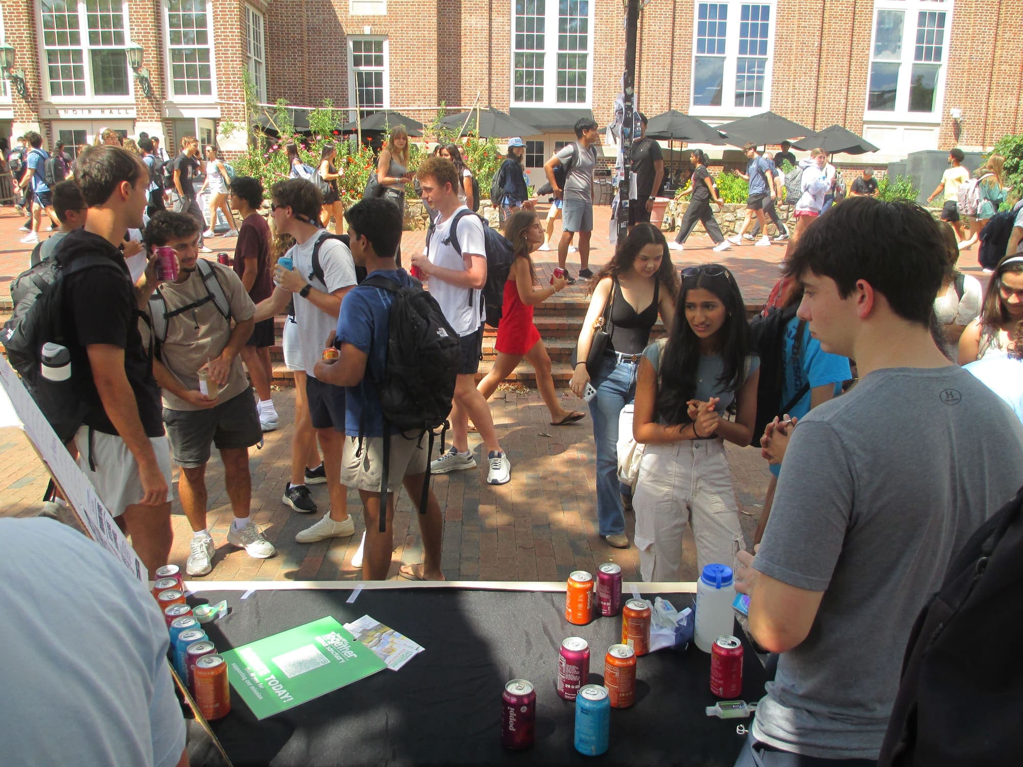 Students crowding around the Phi Chi Theta table outside Student Stores